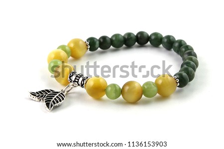 Colorful young girl bracelet isolated on white with green prehnite, yellow cat's eye tiger's eye and dark green canadian jade stones and silver leaf figures at middle
