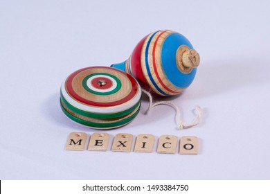 Colorful Yoyo And Spin, Wooden Mexican Toys, And Mexico Made From Wooden Letters On White Background