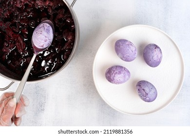 Coloring Easter eggs with natural dye carcade tea from hibiscus flowers. Trendy very peri colour with marble effect. Selective focus.
