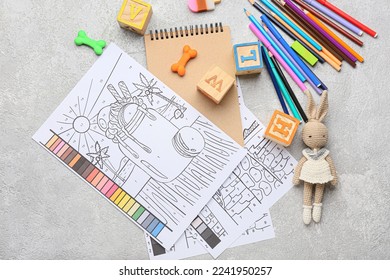 Coloring pages, felt-tip pens, pencils, notebook and toys on grunge background