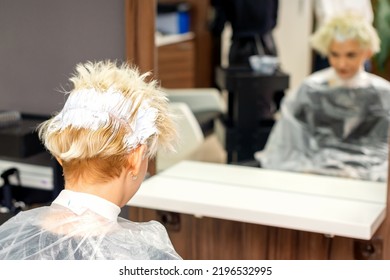 Coloring White Hair With Hair Dye Of The Young Caucasian Blonde Woman Sitting At A Hair Salon, Close Up