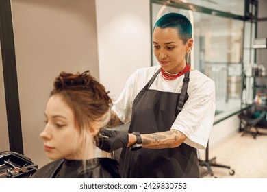 Colorist dyes hair of woman with brush and foil in beauty salon. Professional hair care products - Powered by Shutterstock