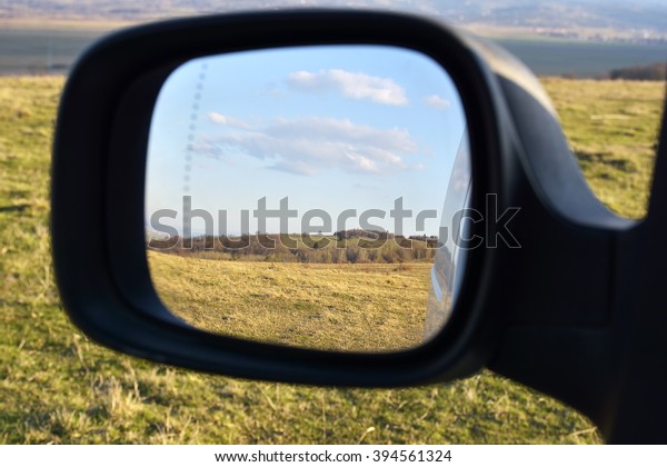 Colors of \
countryside as seen from car\
mirror.