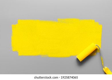 Colors Of The Year 2021 Ultimate Gray And Illuminating Yellow. Paint Roller Painting A Yellow Stripe On A Gray Background. Minimalistic Composition With Copy Space