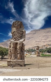 The Colossi of Memnon, two massive quartzite stone statues dedicated of the Pharaoh Amenhotep III. Completion date 1350 BCE, height 18 m (60 ft), weigh 720 tons each. Location West of Luxor, Egypt. - Shutterstock ID 2231084273