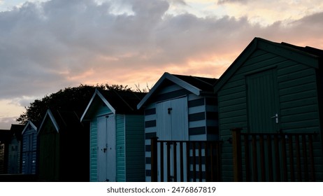 Coloured beach huts at sunset with cloudy sky - Powered by Shutterstock