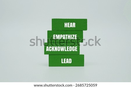 A coloured block with text HEAR, EMPATHIZE, ACKNOWLEDGE, LEAD. Personal growth, leadership and business inspiration concept