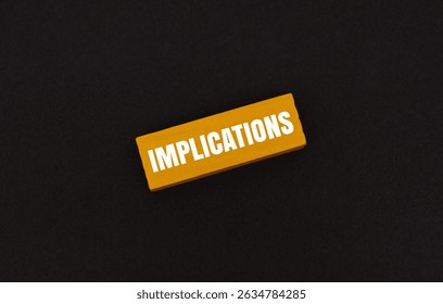 A coloured block with text IMPLICATIONS on dark background