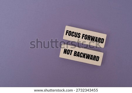 A coloured blocks with text FOCUS FORWARD, NOT BACKWARD. Personal growth, goal setting and positive mindset concepts