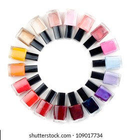 Coloured nail polish bottles stacked circle on a white background