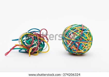 Coloured rubber band ball next to messy pile