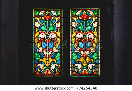 coloured stained glass window colored in a dark background church