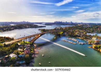 Colourful Aerial View Over Parramatta River And Gladesville Bridge On Victoria Road Towards Sydney City CBD Skyline. Speed Boat Beats The City Traffic On Open River Water.