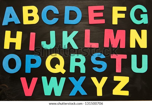 Colourful alphabet\
magnets stuck on\
blackboard