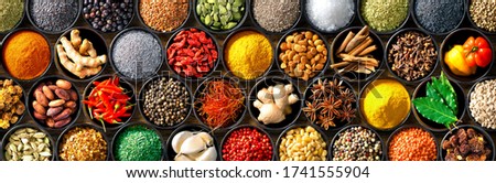 Colourful background from various herbs and spices for cooking in bowls. Top view