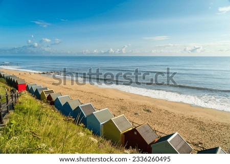 Colourful beach huts on the beach in Mundesley, North Norfolk, UK on a summer morning