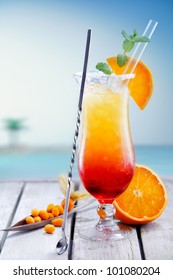 Colourful Exotic Tequila Sunrise Cocktail Served On The Rocks With Crushed Ice And A Swizzle Spoon