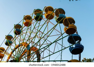 A Colourful Ferris Wheel. Front View. Against The Blue Sky On A Sunny Day