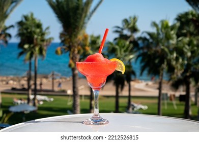 Colourful Frozen Pink Strawberry Daiquiri Cocktail Drink Served In Glass At Outdoor Cafe Overlooking Blue Sea And Palm Trees, Relax And Holidays At Sea