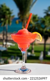 Colourful Frozen Pink Strawberry Daiquiri Cocktail Drink Served In Glass At Outdoor Cafe Overlooking Blue Sea And Palm Trees, Relax And Holidays At Sea