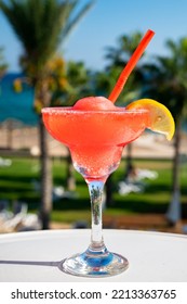 Colourful Frozen Pink Strawberry Daiquiri Cocktail Drink Served In Glass At Outdoor Cafe Overlooking Blue Sea And Palm Trees, Relax And Holidays At Sea