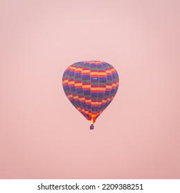 Colourful Hot Air Ballon Flying During A Pastel Pink Sunrise In Cappadocia, Turkey