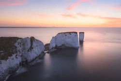 Colourful, Idyllic Sunset Or Sunrise Sky Over Seascape Landscape Of The White Chalk Cliffs And Sea Stacks Of Old Harry Rocks On The Jurassic Coast In Dorset, England, UK.