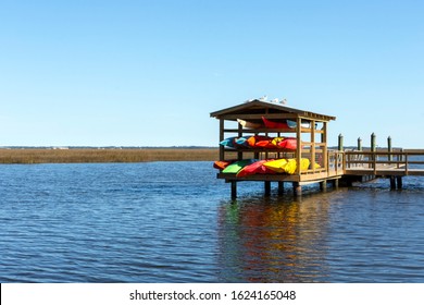 Colourful kayaks are stored on a dock overlooking the beautiful lowcountry salt marsh between Jekyll Island and St. Simons Island, Georgia, in the southeastern United States.