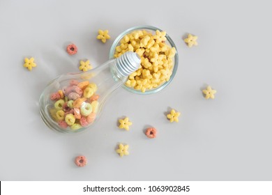 Colourful loops corn flakes in a glass / light bulb and yellow star cornflakes in a bowl for breakfast.(breakfast is the best meal concept)