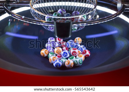 Colourful lottery balls in a rotating bingo machine.