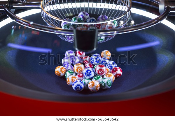 Colourful\
lottery balls in a rotating bingo\
machine.