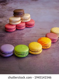 Colourful macarons in semicircle in front on macaron pyramid