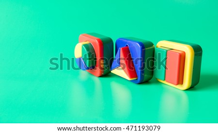 Colourful mix of round, triangle and square shape. Isolated on green background. Slightly de-focused and close-up shot. Copy space.