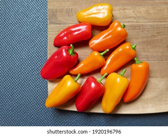 Colourful Peppers On Wooden Chopper Board