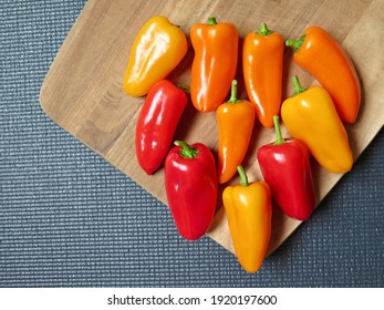 Colourful Peppers On Wooden Chopper Board