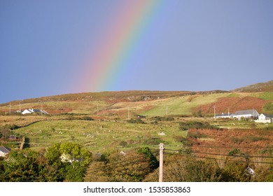Colourful Rainbow In Irish Landscape Landing On A Large Rolling Hills