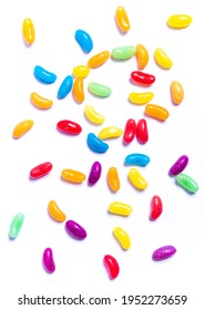 Colourful rainbow jelly beans candies scattered on white background. Festive glucose sweets for confectionary store