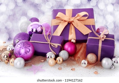 Colourful red Christmas gift decorated with a gold ribbon and bow in winter snow with a bokeh of falling snowflakes and copyspace for your seasonal greeting - Powered by Shutterstock