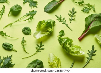 Colourful salad flat design on green background. Romaine, arugula, spinach and mizuna leaves flatlay. Vegan meal ingredients - Shutterstock ID 1666847404