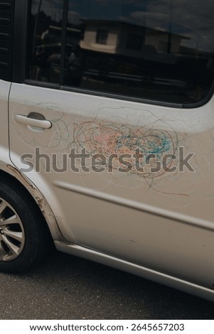 Colourful scribbles on a gray car, Naoshima, Japan