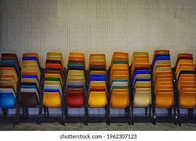 Colourful Stacks Of Chairs Against Wall. Concept Of Education, Teaching, Learning, College, School, Seminar, Class Suspension, E-learning)  