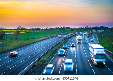 Colourful sunset at M1 motorway near Flitwick junction with blurry cars in United Kingdom.