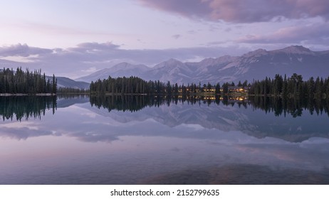 Colourful sunset on mirrorlike lake with mountains in backdrop, Jasper National Park, Canada