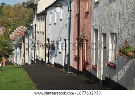 A colourful terrace of cottages sloping downhill in Bradninch, Devon