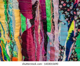 Colourful Torn Fabric Strips, Cords And Wool, Sewn Together In A Striped Pattern. Textile Art Textured Background.