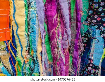 Colourful Torn Fabric Strips, Cords And Wool, Sewn Together In A Striped Pattern. Textile Art Textured Background.