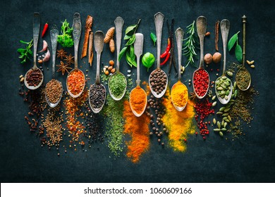 Colourful various herbs and spices for cooking on dark background 