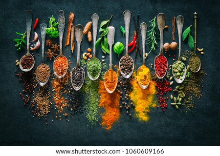Colourful various herbs and spices for cooking on dark background 