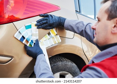 Colourist Man Selecting Color Of Car With Paint Matching Samples