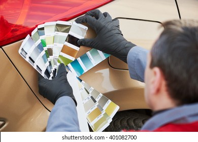 Colourist Man Selecting Color Of Car With Paint Matching Samples